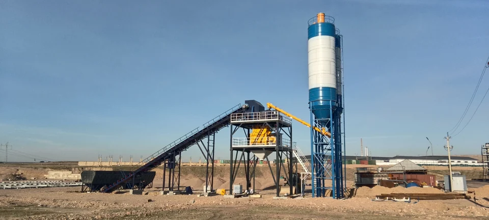 Belt-fed concrete batching installation with aggregate bins and a cement silo